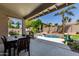 Outdoor patio with dining table, overlooking lush landscaping and a sparkling pool at 6958 W Morning Dove Dr, Glendale, AZ 85308