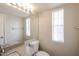 Light-filled bathroom with a gray countertop, white toilet, and natural light from a bright window at 7110 N 28Th Dr, Phoenix, AZ 85051