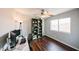 Bright bedroom featuring hardwood floors, a ceiling fan, a bookcase, and a large window at 7110 N 28Th Dr, Phoenix, AZ 85051