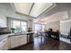 Modern kitchen with stainless steel appliances, white cabinets, dark wood-style flooring, and a dining nook at 7110 N 28Th Dr, Phoenix, AZ 85051