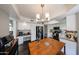 Well-lit kitchen with white cabinets, a black refrigerator, and a view of the dining area at 7110 N 28Th Dr, Phoenix, AZ 85051