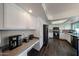 Bright kitchen featuring white cabinets, stainless steel appliances, and dark wood-style flooring at 7110 N 28Th Dr, Phoenix, AZ 85051