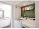 Convenient laundry room with modern washer and dryer, storage shelves, and a nearby bathroom at 7110 N 28Th Dr, Phoenix, AZ 85051