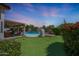 Amazing backyard featuring a putting green, shimmering pool, stone fireplace, and covered patio for entertaining at 7307 E Black Rock Rd, Scottsdale, AZ 85255