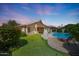 Expansive backyard with putting green, sparkling pool, and a cozy stone fireplace ideal for outdoor gatherings at 7307 E Black Rock Rd, Scottsdale, AZ 85255