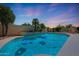 Inviting pool with sparkling water, palm trees, and a charming stone fireplace creates a relaxing backyard oasis at 7307 E Black Rock Rd, Scottsdale, AZ 85255