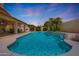 Gorgeous pool with a waterfall feature, covered patio, and lush landscaping perfect for outdoor entertaining at 7307 E Black Rock Rd, Scottsdale, AZ 85255