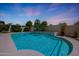 Beautiful backyard with a sparkling blue pool, lush greenery, and a tranquil waterfall for relaxation at 7307 E Black Rock Rd, Scottsdale, AZ 85255