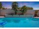 Inviting pool with a built-in waterfall feature and tropical landscaping creating a backyard paradise at 7307 E Black Rock Rd, Scottsdale, AZ 85255