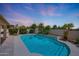 Serene backyard oasis with a sparkling pool, mature landscaping, and a soothing waterfall feature at 7307 E Black Rock Rd, Scottsdale, AZ 85255