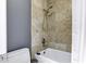 Bathtub and shower with tan tiles, a showerhead, and neutral tones at 8936 N 80Th Pl, Scottsdale, AZ 85258
