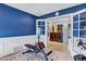 Bright exercise room with French doors, fitness equipment, and accent wall at 8936 N 80Th Pl, Scottsdale, AZ 85258