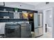 Modern laundry room featuring washer, dryer, refrigerator, and shelving for storage at 8936 N 80Th Pl, Scottsdale, AZ 85258