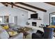 Cozy living room with white brick fireplace, exposed wood beams, and comfortable seating area at 8936 N 80Th Pl, Scottsdale, AZ 85258