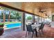 Covered patio with ceiling fans overlooking a sparkling pool and lush backyard oasis, ideal for entertaining at 8936 N 80Th Pl, Scottsdale, AZ 85258
