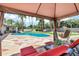 Relaxing poolside view from the gazebo with comfortable seating, overlooking the sparkling pool and lush greenery at 8936 N 80Th Pl, Scottsdale, AZ 85258