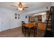 Bright dining area with an adjacent kitchen, hardwood flooring, ceiling fan, and natural light at 9051 E Grandview Dr, Mesa, AZ 85207
