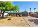 Charming single-story home featuring a well-manicured lawn, mature tree, and a welcoming red front door at 9051 E Grandview Dr, Mesa, AZ 85207