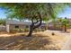 Charming single-story home with desert landscaping, mature tree, and a two car garage at 9051 E Grandview Dr, Mesa, AZ 85207