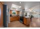 Modern kitchen with wooden cabinets, stainless steel appliances, and a view of the living area at 9051 E Grandview Dr, Mesa, AZ 85207