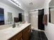 Well-maintained bathroom featuring a sink vanity, toilet, and shower with black accents at 9221 N 48Th Dr, Glendale, AZ 85302