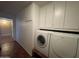 Bright laundry area featuring a Bosch washer and dryer, ample cabinet space, and vinyl flooring at 9221 N 48Th Dr, Glendale, AZ 85302