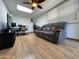 Cozy living space featuring a comfortable gray leather sofa, ceiling fan, and a functional desk area at 9221 N 48Th Dr, Glendale, AZ 85302