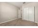 Neutral carpeted bedroom with an en-suite bathroom and a closet with sliding doors at 9535 E Tupelo Ave, Mesa, AZ 85212