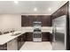 Modern kitchen with stainless steel appliances, dark wood cabinets, and an open layout at 9535 E Tupelo Ave, Mesa, AZ 85212