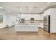 A well-lit kitchen features white cabinets, stainless steel appliances, a center island and wood floors that offer modern elegance at 970 W Zion Way, Chandler, AZ 85248