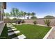Inviting backyard with a manicured lawn, paver accents and comfortable seating area at 1026 N 152Nd Ave, Goodyear, AZ 85338
