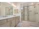 Bathroom featuring double vanity and glass-enclosed shower with designer pebble tile at 1026 N 152Nd Ave, Goodyear, AZ 85338
