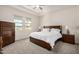 Bright bedroom featuring neutral carpet, tray ceiling, and large windows at 1026 N 152Nd Ave, Goodyear, AZ 85338
