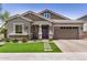 Beautiful home showcasing a lush lawn, brick details, and an attached two-car garage at 1026 N 152Nd Ave, Goodyear, AZ 85338