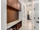 Organized mud room with bench, shelving, and hallway leading to laundry area at 1026 N 152Nd Ave, Goodyear, AZ 85338
