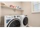 Well-organized laundry room featuring modern washer, dryer, and ample shelf storage for supplies at 1153 W Diamondback Dr, Chandler, AZ 85286