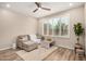 Bright living room with wood floors, ceiling fan, neutral sofa, and large windows at 1153 W Diamondback Dr, Chandler, AZ 85286