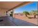 Covered back porch with desert landscaping, including small palm trees at 12910 W Junipero Dr, Sun City West, AZ 85375
