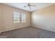 Neutral bedroom with carpeted floor, blinds on the windows, and a ceiling fan at 12910 W Junipero Dr, Sun City West, AZ 85375
