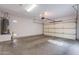 Empty, two-car garage with bare concrete floor and an insulated garage door at 12910 W Junipero Dr, Sun City West, AZ 85375