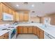 Bright kitchen features wooden cabinetry, white countertops and flows nicely into the living spaces at 12910 W Junipero Dr, Sun City West, AZ 85375