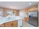 Bright kitchen features wooden cabinetry, white countertops, stainless steel appliances and bright chandelier at 12910 W Junipero Dr, Sun City West, AZ 85375