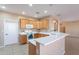 Bright kitchen features wooden cabinetry, white countertops, tiled flooring and open layout to the living room at 12910 W Junipero Dr, Sun City West, AZ 85375
