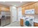 Bright kitchen features wooden cabinetry, white countertops and stainless steel appliances at 12910 W Junipero Dr, Sun City West, AZ 85375