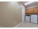 Laundry room with a side-by-side washer and dryer and upper cabinets at 12910 W Junipero Dr, Sun City West, AZ 85375