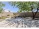 Backyard view with mature tree and fire pit set against a stucco wall and lush vegetation at 1311 N Congress Dr, Chandler, AZ 85226