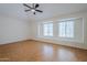Spacious bedroom with hardwood floors, a ceiling fan, and two bright windows offering natural light at 1311 N Congress Dr, Chandler, AZ 85226
