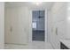 Bright hallway with tiled floors and built-in storage cabinets leading to a carpeted living room with ceiling fan at 1311 N Congress Dr, Chandler, AZ 85226