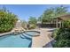 Backyard oasis showcasing the pool, spa, rock waterfall, and surrounding greenery at 1311 N Congress Dr, Chandler, AZ 85226
