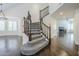 Dramatic staircase with wood banister, leading to large living room with fireplace at 1311 N Congress Dr, Chandler, AZ 85226